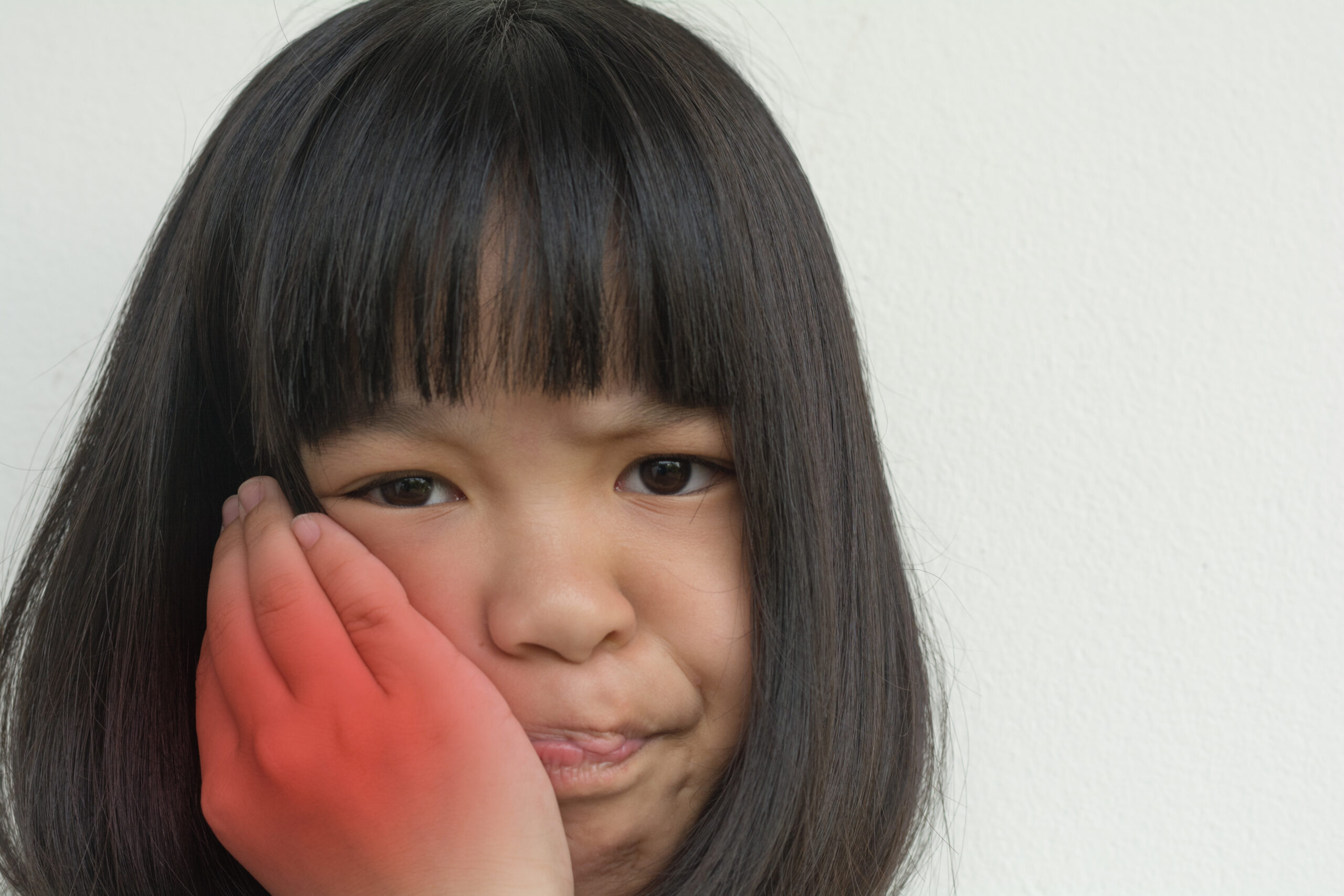 TMD and TMJ healthcare concept: Temporomandibular Joint and Muscle Disorder. Asia child kid girl hand on cheek face as suffering from facial pain, mumps or toothache TMD and TMJ healthcare concept: Temporomandibular Joint and Muscle Disorder. Asia child kid girl hand on cheek face as suffering from facial pain, mumps or toothache