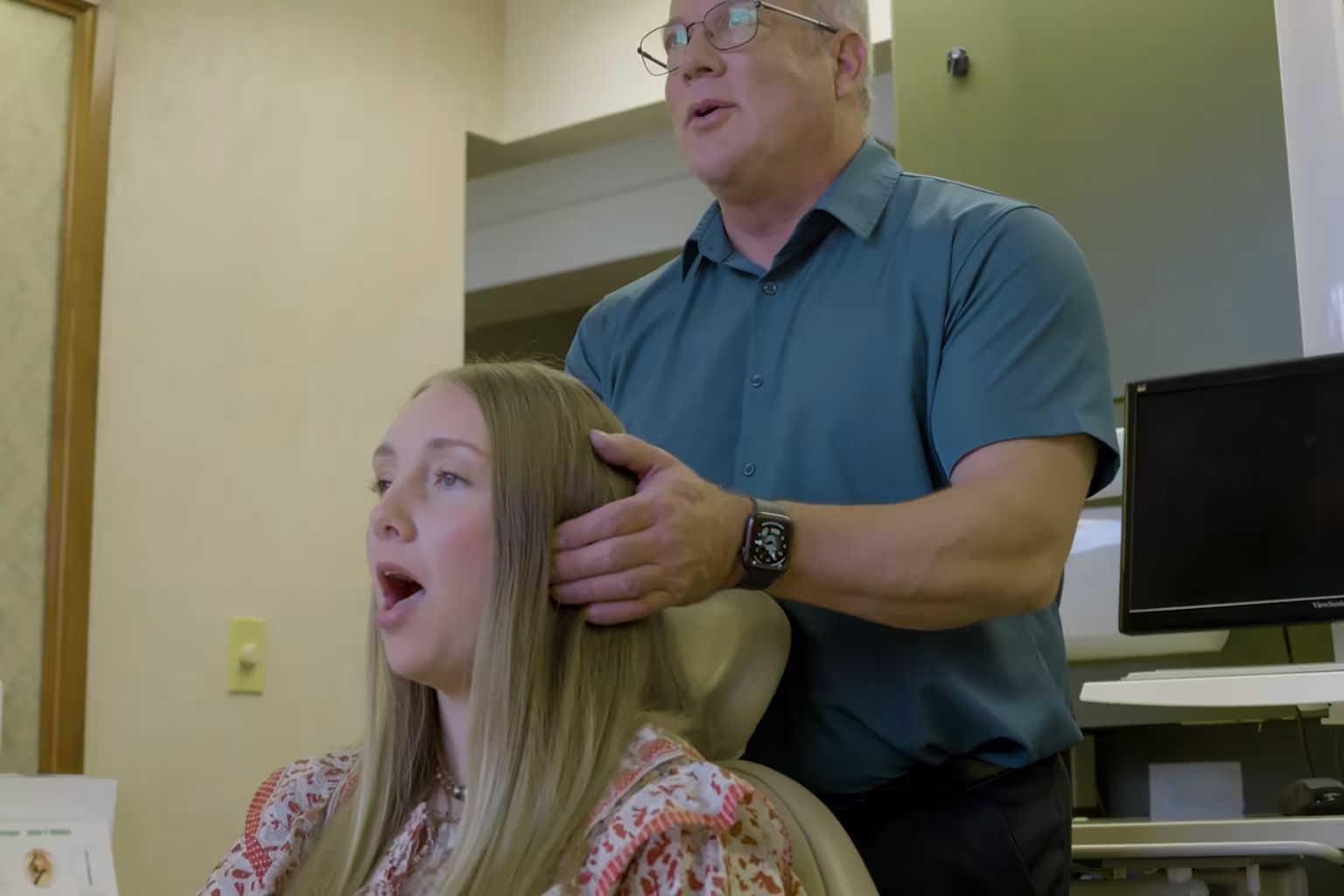 Dr. K. Cheyn Gunnerson checking a patient's jaw movement as she opens her mouth