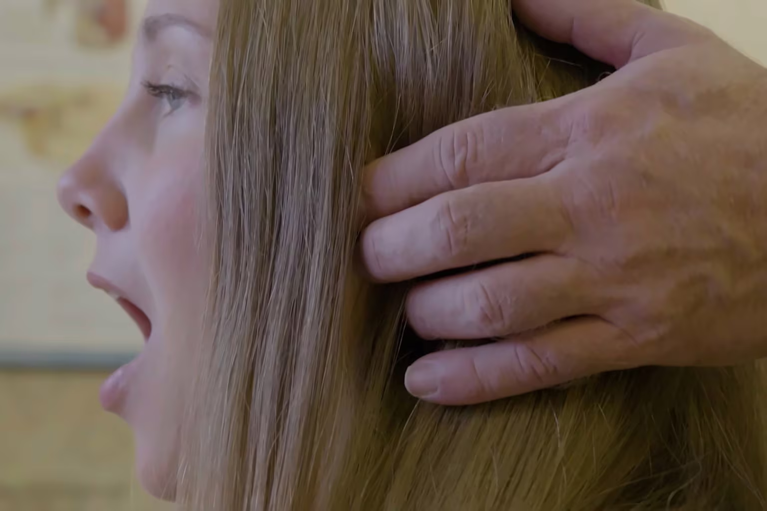 Dr. K. Cheyn Gunnerson palpating the jaw joint just in front of a patient's ear as she opens her mouth