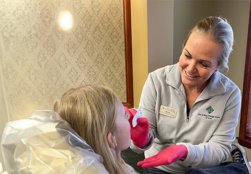 Mindy Lunceford, myofunctional therapist, guiding a young patient through a tongue and lip exercise